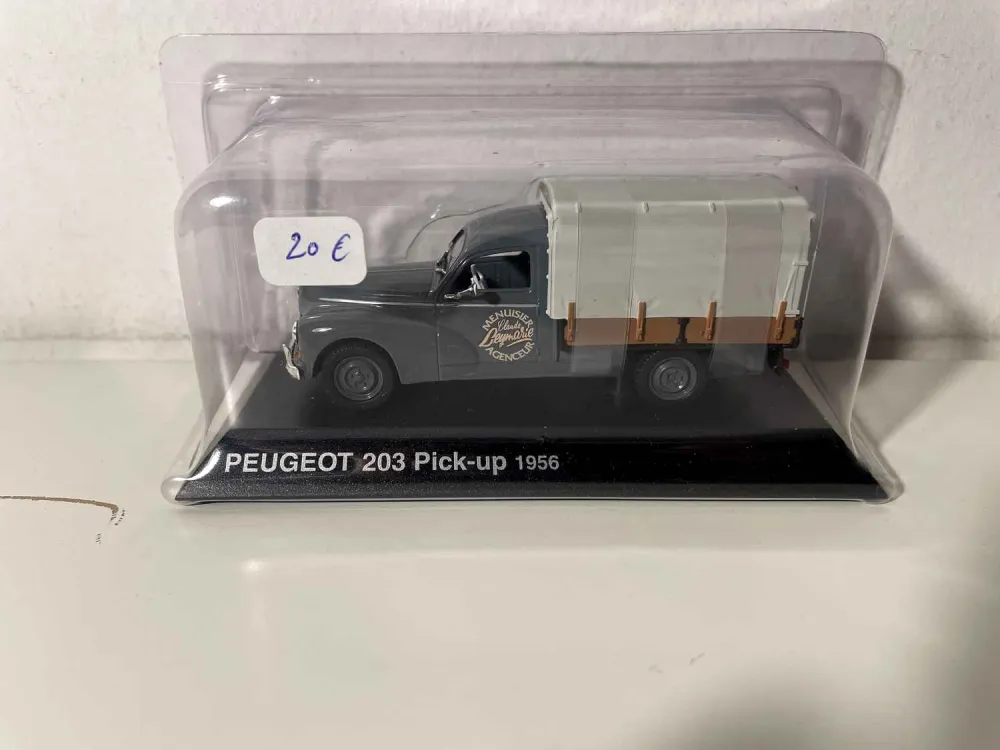 Pick-up Peugeot 203 grigio con telone del 1956 (con pubblicità di un'azienda di falegnameria sulla portiera)